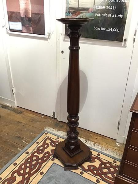 An early 20thc mahogany torchere, the circular dish top on a baluster stem, with gadroon detail on