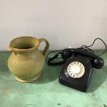 A black 1970s plastic telephone with circular dial and modern cable fitting (h.10cm), and a