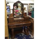 A mid Victorian mahogany dressing table, the raised superstructure with hinged compartment and two