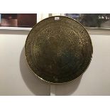 A Middle Eastern brass table top, decorated with intricate radiating designs and Islamic script (d.