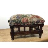 A small Edwardian mahogany footstool, the upholstered top above a spindle gallery, raised on