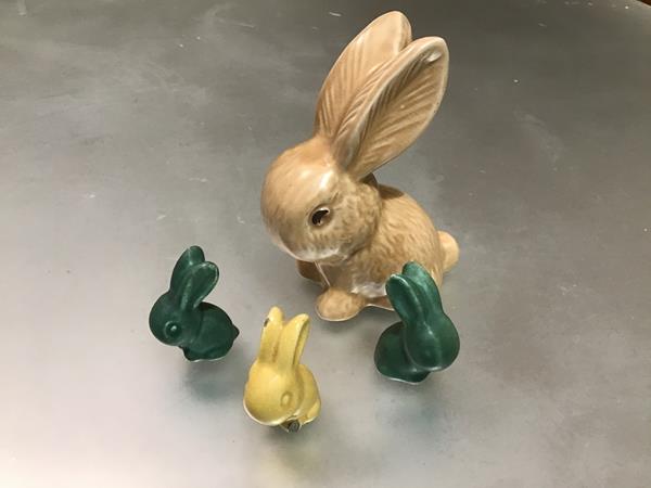 A set of four rabbits, one stamped Sylvac decorated with green and yellow glaze (tallest: 12.5cm)