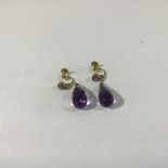 A pair of late 19thc/20thc amethyst faceted pear shaped drop earrings on suspension chains, with