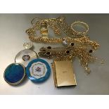 A collection of gilt chains, three compacts, a miniature clock, a miniature notebook, a bangle, a