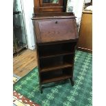 A 1940s oak fall front bureau, the three quarter gallery above a fall front and three open