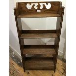 A 1930s oak bookshelf, the back with pierced fretwork detail above four shelves, enclosed by