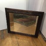 An Edwardian oak relief carved C scroll leaf border wall mirror with bevelled glass plate (60cm x