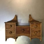 An Edwardian oak child's dressing table (missing mirror), fitted central frieze drawer, flanked by a