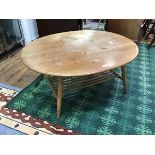 An elm mid century coffee table, probably by Ercol, the oval top on turned swollen legs, with turned