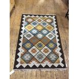 A kelim rug, the geometric field variously decorated with serrated motifs in blue, camel and
