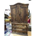 A Continental style hardwood linen press, the pair of arched panel doors enclosing hanging space,