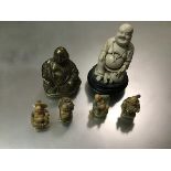 A collection of buddhas including a brass seated buddha, a white resin, seated and four small