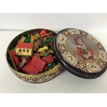 A tin with a collection of treen decorated farmyard animals, farm buildings, fences etc.