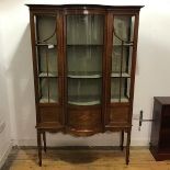 An Edwardian mahogany and inlaid bow front display cabinet, the projecting cornice above a pair of