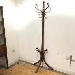 A bentwood hat and coat stand with turned knop finial and scrolling branches, above a hooked coat