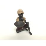 A cast bronzed metal Beggar figure (h.13cm), decorated with polychrome enamels