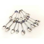 A collection of sixteen various silver enamelled souvenir teaspoons (179g)