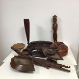 A collection of tribal carved wood artefacts including two navette shaped bowls, two circular bowls,