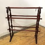 A reproduction turned wood towel rail, the arched frame with five turned rods, raised on a