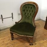 A Victorian mahogany framed nursing chair with green button back upholstery within a moulded frame