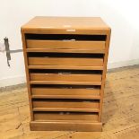 A mid century beech chest, the rectangular top above six slides, raised on a plinth base (76cm x