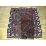 A North West Persian rug, the blue field with central red medallion and spandrels within ivory and