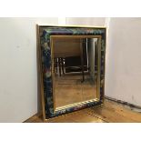 A bevelled glass mirror within a gilt and painted cushion frame, with fruit and floral painted