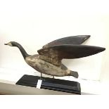 An American style folk art treen carved goose decorated with polychrome enamels, mounted on