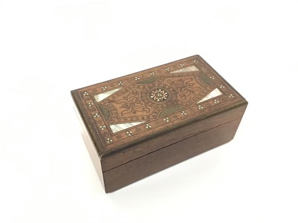 An Eastern sandalwood box with inlaid mother of pearl, copper etc., in stylised decoration (4cm x