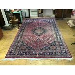 A large North West Persian carpet, the abrashed salmon pink field with central indigo medallion