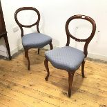 A pair of Victorian walnut balloon back armchairs each channel moulded back incorporating carved C