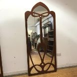 A painted wall mirror in the Art Nouveau style, with pierced and arched details applied over a