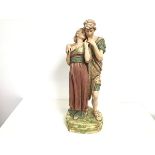 A Royal Dux porcelain figure group, Young Couple Standing, raised on naturalistic moulded base,