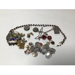 A mixed lot including an Indian enamelled pendant, a charm bracelet, a silver ingot on chain, a pair