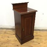 A late Victorian mahogany and satinwood banded pot cupboard, the raised back above a moulded top and