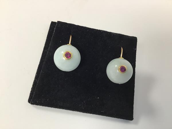 A pair of pale celadon jadeite ball earrings mounted on yellow metal hoop posts with pink tourmaline