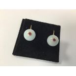 A pair of pale celadon jadeite ball earrings mounted on yellow metal hoop posts with pink tourmaline