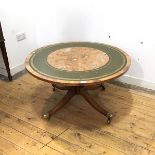 A yew wood and tooled leather mounted centre table, the crossbanded circular top raised on a