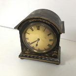 A 1920s lacquered mantel clock with chinoiserie decoration, with arched top over a metal dial with