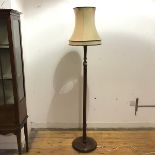 A mid 20thc oak floor lamp, the turned stem with fluted and baluster shaped details, raised on a