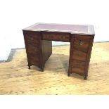 An Edwardian mahogany kneehole desk, the inverted breakfront top with crossbanded border and vinyl