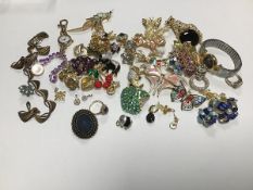 A large assortment of gilt paste set brooches including floral clusters, a koala, an owl, elephant