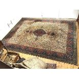 A Wilton machine made carpet, the ivory field with central indigo medallion decorated with