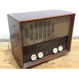 A Ferranti walnut cased mid century radio, with medium, long and FM, with four cream plastic nobs,