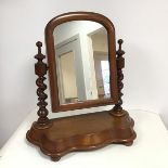 A mid 20thc mahogany dressing table mirror, the glass in an arched frame flanked by two barley twist