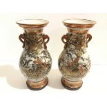 A pair of Japanese Satsuma baluster vases decorated with figures beside a lake and Samuri