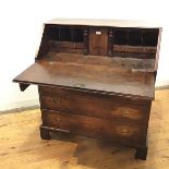 A George III oak fall front bureau, c.1790, the rectangular fall front enclosing a fitted interior
