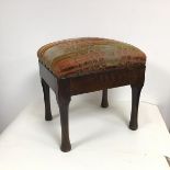A mid 20thc footstool with a polychrome synthetic cover (worn) on an elm frame with turned