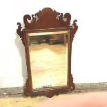A George III mahogany fretwork mirror with scroll surmount to top, with rectangular moulded frame