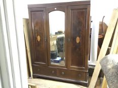 An Edwardian mahogany and inlaid mirror door wardrobe with a pair of panel cupboard doors, enclosing